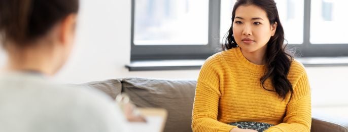 Two adults having a conversation in a calm consultation setting.