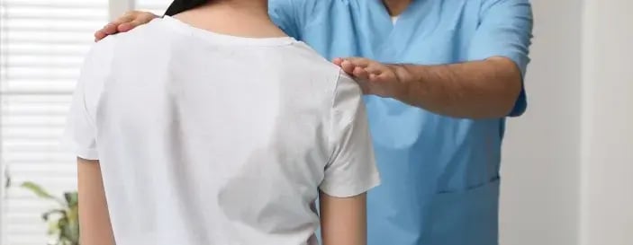 Orthopedist Examining Woman in Clinic. Scoliosis Treatment
