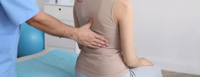 Orthopedist Examining Womans Back in Clinic, Closeup. Scoliosis Orthopedist Examining Womans Back in Clinic, Closeup. Scoliosis