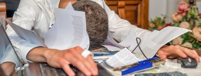 Businessman appearing overwhelmed at work, illustrating stress and burnout.