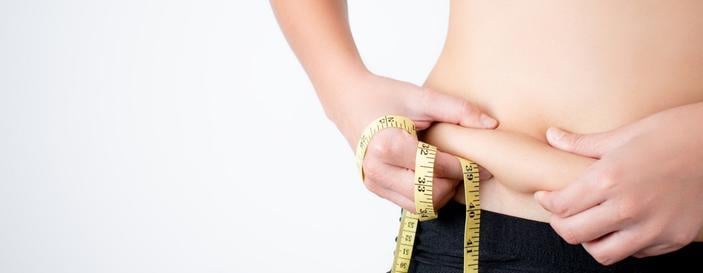 Young-woman-captures-excess-fat-on-her-belly-with-a-fat-tape