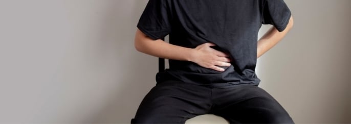 男士手按下腹部，疑似小腸氣引起不適