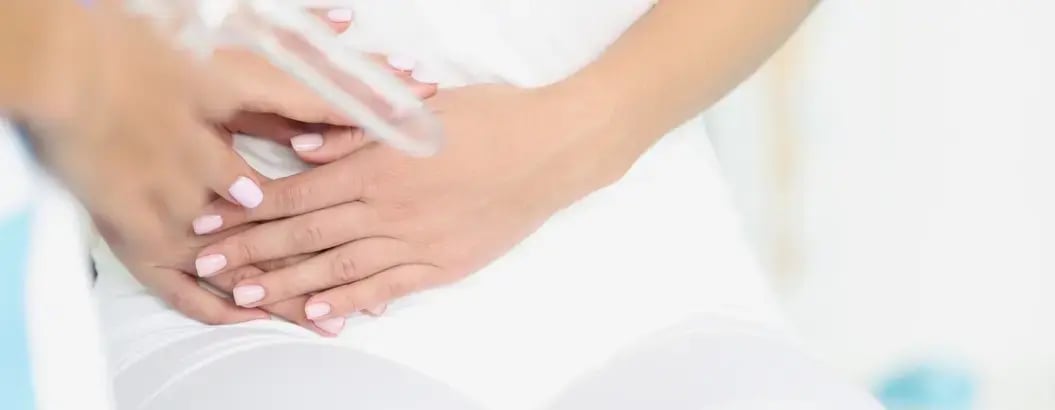 女性按住下腹部，示意與婦科健康相關的不適症狀。