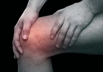 男子按住膝蓋，示意膝關節疼痛及不適。