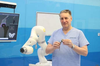 Dr. Jason Brockwell with Joint Implant and Robotic Arm