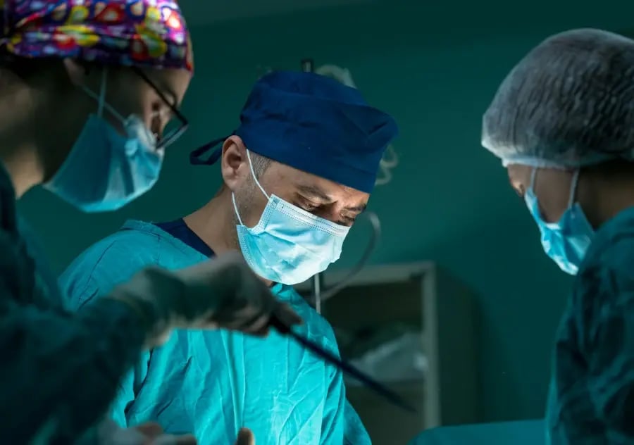 three doctors performing surgery on patient