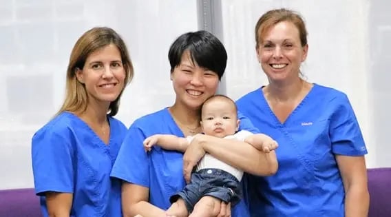 three nurses caring for a baby