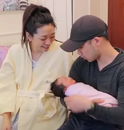 tiffany and her husband holding their newborn baby
