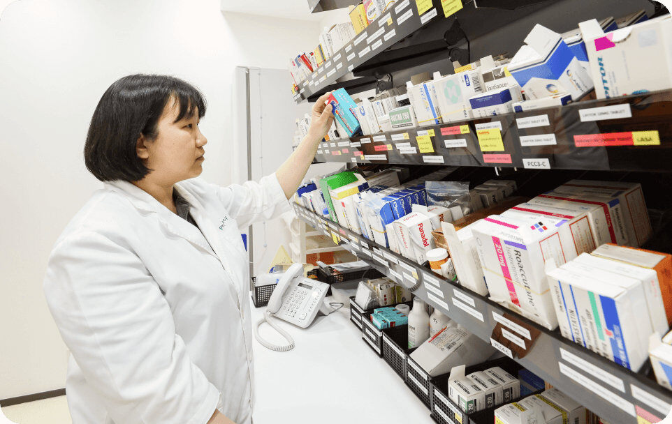 female pharmacist picking out medicine in pharmacy
