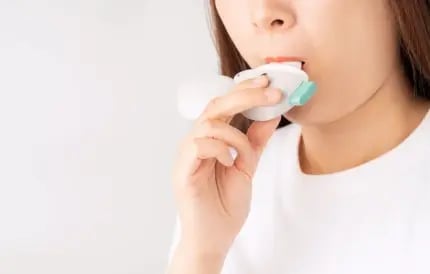 women inhaling inhaler