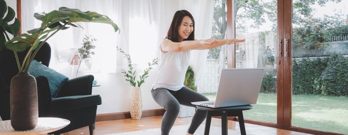 Woman Learning Online Workout Exercises at Home